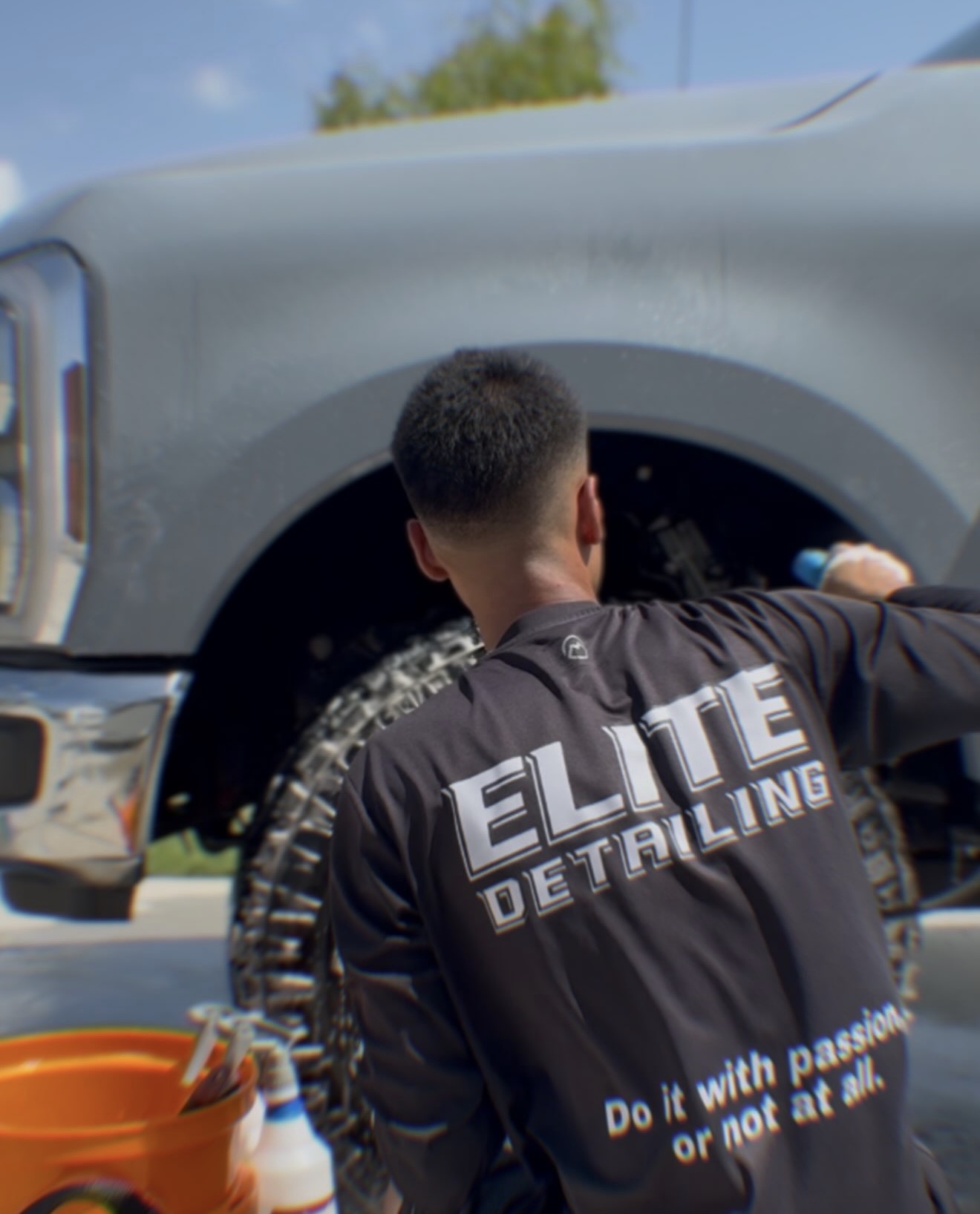 Elite Detailing technician cleaning the wheel of a freshly detailed truck